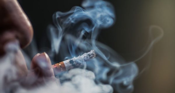 closeup-shot-person-puffing-cigarette-surrounded-with-smoke