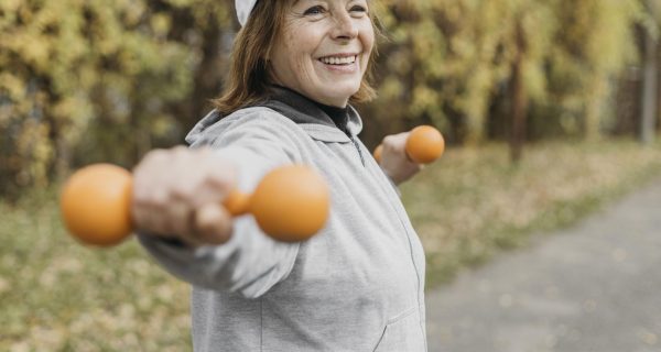 mulher-idosa-sorridente-fazendo-exercicios-com-pesos-ao-ar-livre