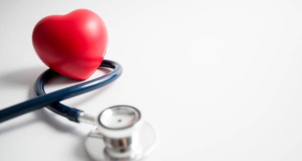 Red heart with stethoscope on white background, heart health, health insurance concept, world health day.